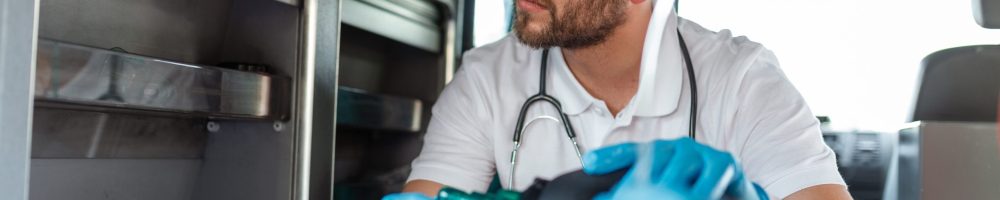 EMS Paramedics Team Provide Medical Help to Injured Patient on the Way to Healthcare Hospital. Emergency Care Assistant Using a Non-Invasive Ventilation Mask in an Ambulance. Close-up Shot.